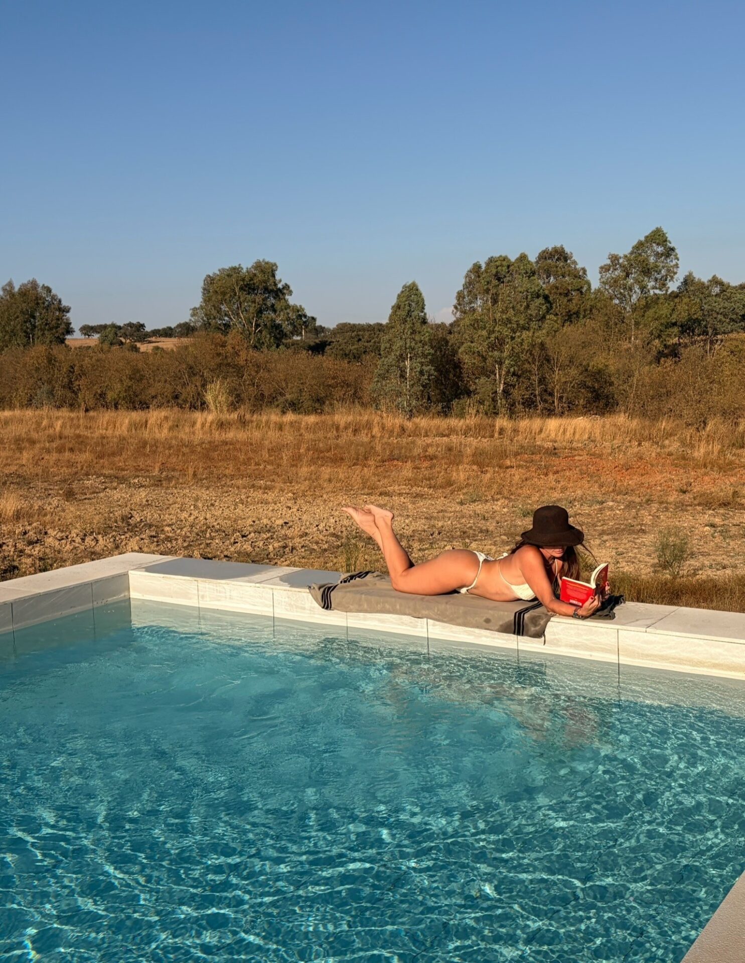 Giovanna Antonelli relaxa à beira da piscina e coloca leitura em dia em Portugal